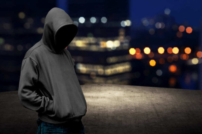 Faceless,Man,In,Hood,On,The,Rooftop,With,City,Background