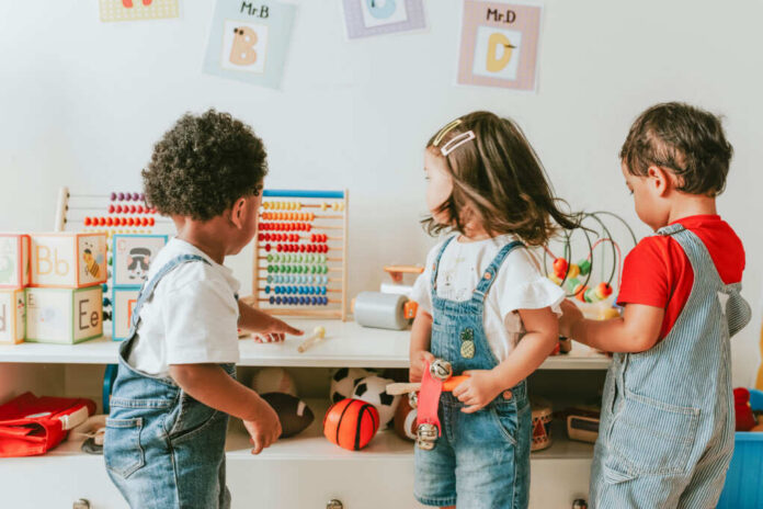 shutterstock1240622437jpg Three children engaged in play with educational toys in a colorful classroom