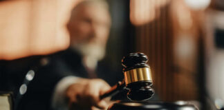 A judge holding a gavel in a courtroom setting