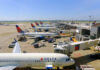 View of multiple Delta Airlines planes parked at an airport terminal with ground crew and vehicles