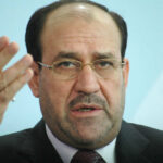 Iran’s Grip on Iraq: Trump’s Stern Warning A political figure speaking at a press conference with a serious expression