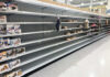 Empty grocery store shelves with a few snack items remaining