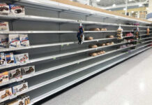 Empty grocery store shelves with a few snack items remaining