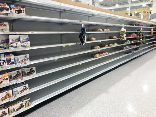 Empty grocery store shelves with a few snack items remaining