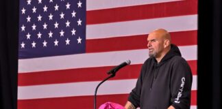 A speaker at a podium in front of an American flag during a political event