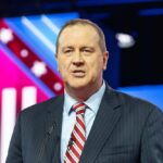 Citizenship REVOCATION Bill Sparks Outrage A man in a suit speaking at a podium during a conference