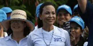 María Corina Machado smiling at a political rally surrounded by supporters
