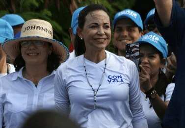 María Corina Machado smiling at a political rally surrounded by supporters