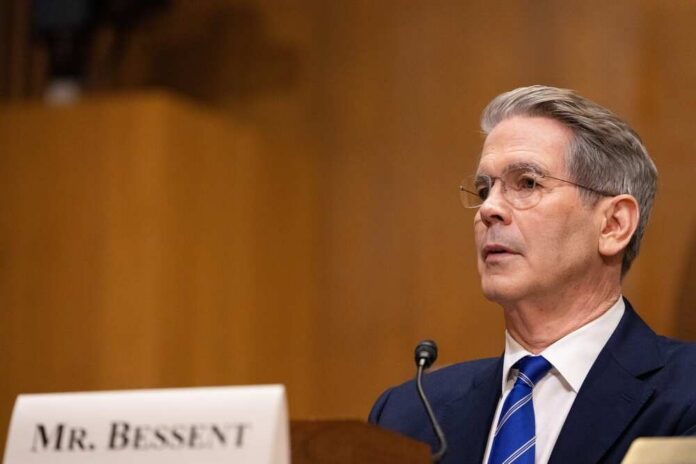 A man in formal attire speaking at a government hearing