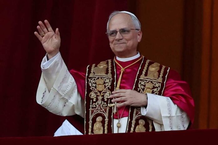 A religious leader in papal attire waving from a balcony