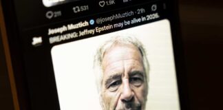 Close-up of a man's face displayed on a smartphone screen with a news headline