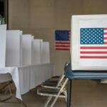 Voting booth with American flag and ballot box in a polling station