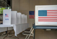Voting booth with American flag and ballot box in a polling station