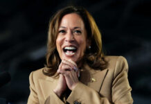 White House Mocks: Harris’s Preemptive Strike Fails A woman in formal attire smiling broadly while speaking at a podium