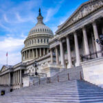 The U.S. Capitol building with its iconic dome and steps under a blue sky