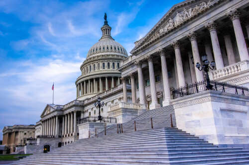 The U.S. Capitol building with its iconic dome and steps under a blue sky