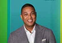 Smiling man in a gray suit with a colorful background