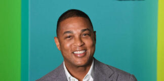 Smiling man in a gray suit with a colorful background