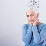 Elderly woman with a unique hairstyle made of puzzle pieces, looking thoughtful