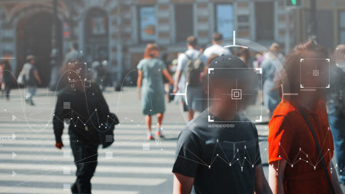 Crowd of people crossing a street with digital overlays indicating facial recognition technology