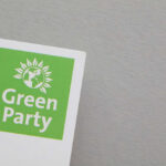 Logo of the Green Party featuring a globe and sun design