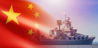 A Chinese warship sailing in the ocean with the Chinese flag in the foreground