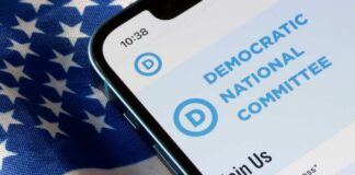 Mobile phone displaying Democratic National Committee website on an American flag background