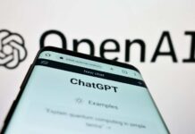 Close-up of a smartphone displaying the ChatGPT interface with the OpenAI logo in the background