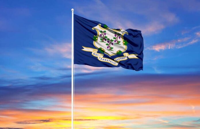 Connecticut state flag waving against a colorful sunset