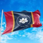 Mississippi state flag waving against a blue sky