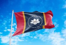 Mississippi state flag waving against a blue sky