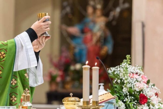 A priest holding a chalice during a church service