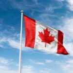 Canadian flag waving against a blue sky
