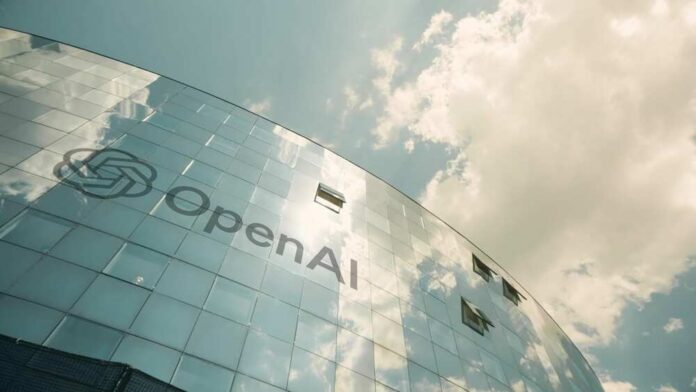 shutterstock_2500976757.jpg A modern glass building with the OpenAI logo against a cloudy sky