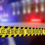 Yellow police tape reading 'DO NOT CROSS' at a crime scene