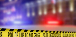 Yellow police tape reading 'DO NOT CROSS' at a crime scene