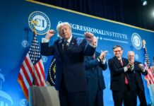 A speaker at a podium celebrating during a political event