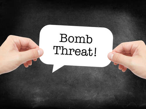 Hands holding a speech bubble with the text 'Bomb Threat'