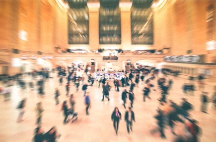 shutterstock_454310260.jpg A busy train station filled with blurred figures of people moving