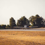 Public Safety Concerns Soar After Fatal Crash A small airplane on a runway surrounded by trees