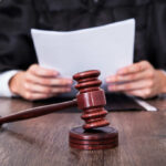 Court Clerk CORRUPTED Trial Nobody Saw Coming A judge holding documents with a gavel in the foreground