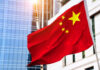 Chinese flag waving in front of modern buildings