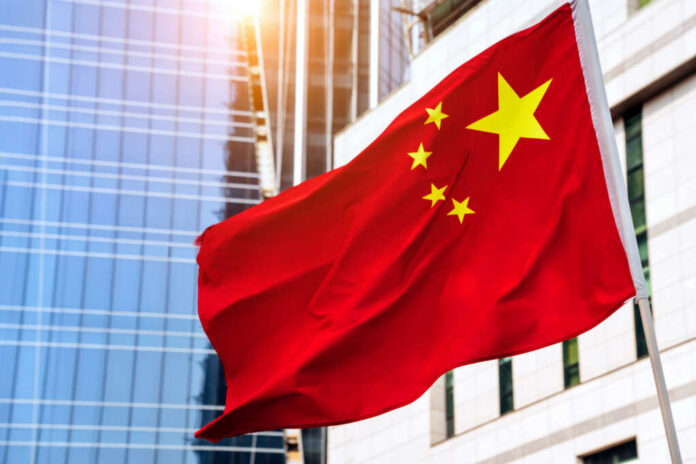 Chinese flag waving in front of modern buildings