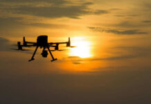 Russian Drone Strikes Chinese Ship! A silhouette of a drone flying against a sunset sky