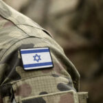 Intense Conflict: Israel Targets Hezbollah Zones! Close-up of a military uniform with an Israeli flag patch
