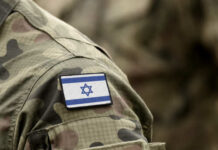 Intense Conflict: Israel Targets Hezbollah Zones! Close-up of a military uniform with an Israeli flag patch