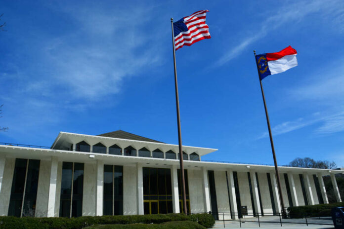Government building with American and North Carolina flags under a clear blue sky