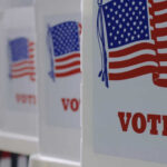 Redrawing Maps: Could This Sabotage Fair Votes? Voting booths with American flags and VOTE signage