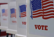 Redrawing Maps: Could This Sabotage Fair Votes? Voting booths with American flags and VOTE signage