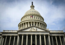 Congress Clashes Over Trump’s Costly War The U.S. Capitol building with an American flag flying in front